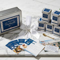 Maison Gabrielle Seasonal spice gift box featuring elegant tins, recipe cards, and a golden spoon on a marble surface.