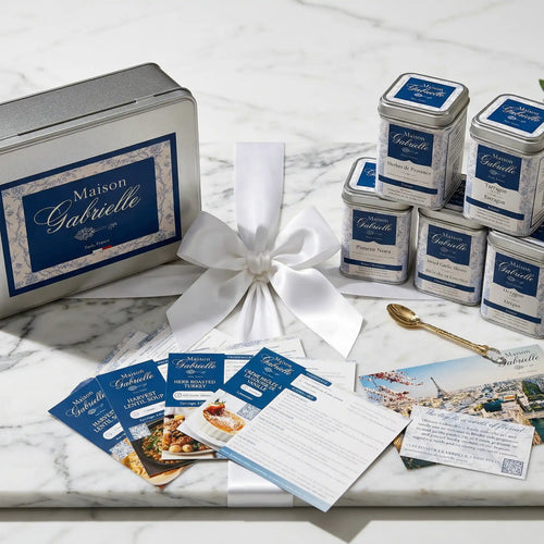 Maison Gabrielle Seasonal spice gift box featuring elegant tins, recipe cards, and a golden spoon on a marble surface.