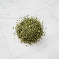 Maison Gabrielle Dried Mint Leaves Piled on a White Marble Surface for Culinary and Tea Use