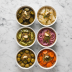 Maison Gabrielle Assorted Bowls of Pickled Vegetables Including Cucumbers, Onions, Olives, and Carrots Seasoned with Yellow and Black Mustard Seed Blend Top View Detail