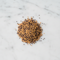 Maison Gabrielle Yellow and Black Mustard Seed Blend Piled on a White Marble Surface for Pickling and Gourmet Recipes